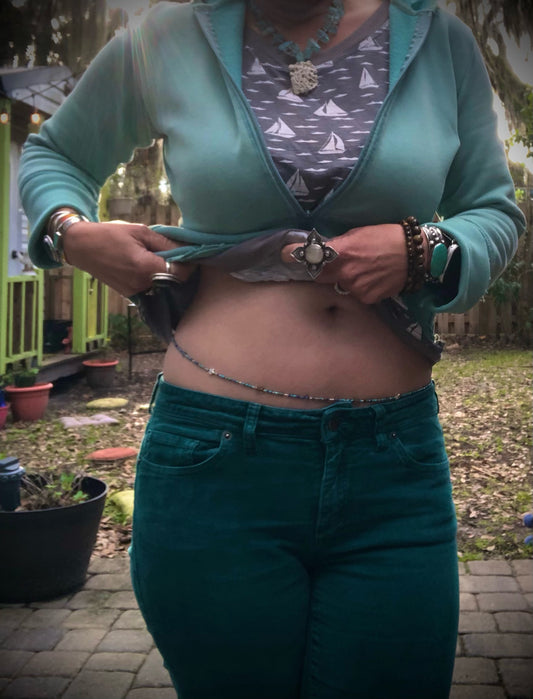 Waist beads in blue, green, and silver glass seed beads, silver plated star beads, multi-colored glass beads, and labradorite beads on elastic cord with a silver plated clasp.