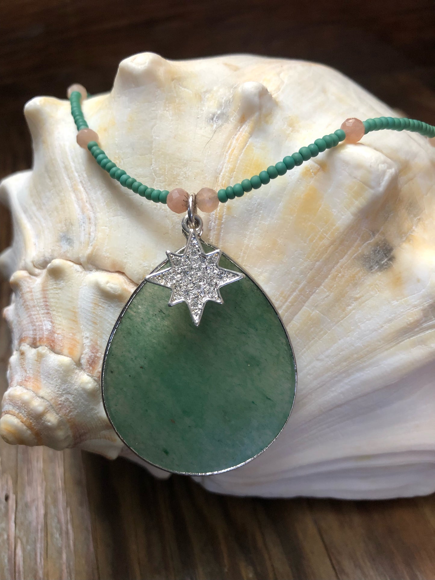 Green aventurine pendant/necklace with peach sunstone beads, green glass seed beads, and 19mm silver plated clear crystal starburst charm.