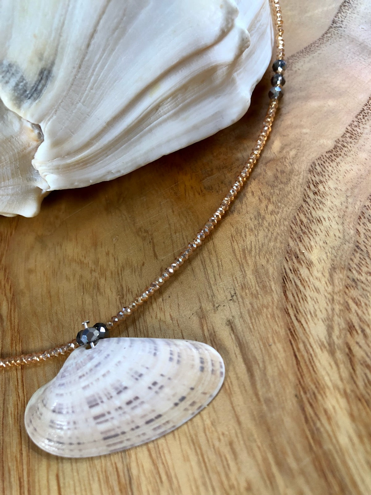 Plaid seashell necklace with faceted peach glass seed beads, and gunmetal faceted Austrian crystal beads.