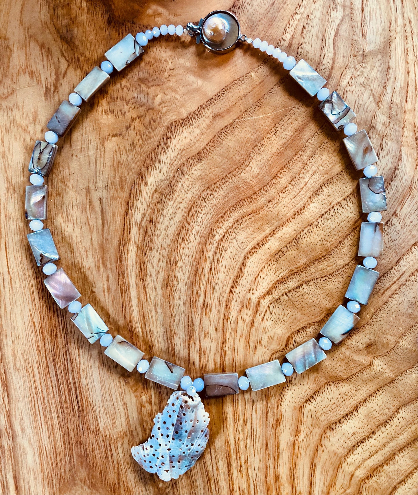 Weather seashell necklace with mother of pearl beads, glass beads, and silver plated pearl clasp.