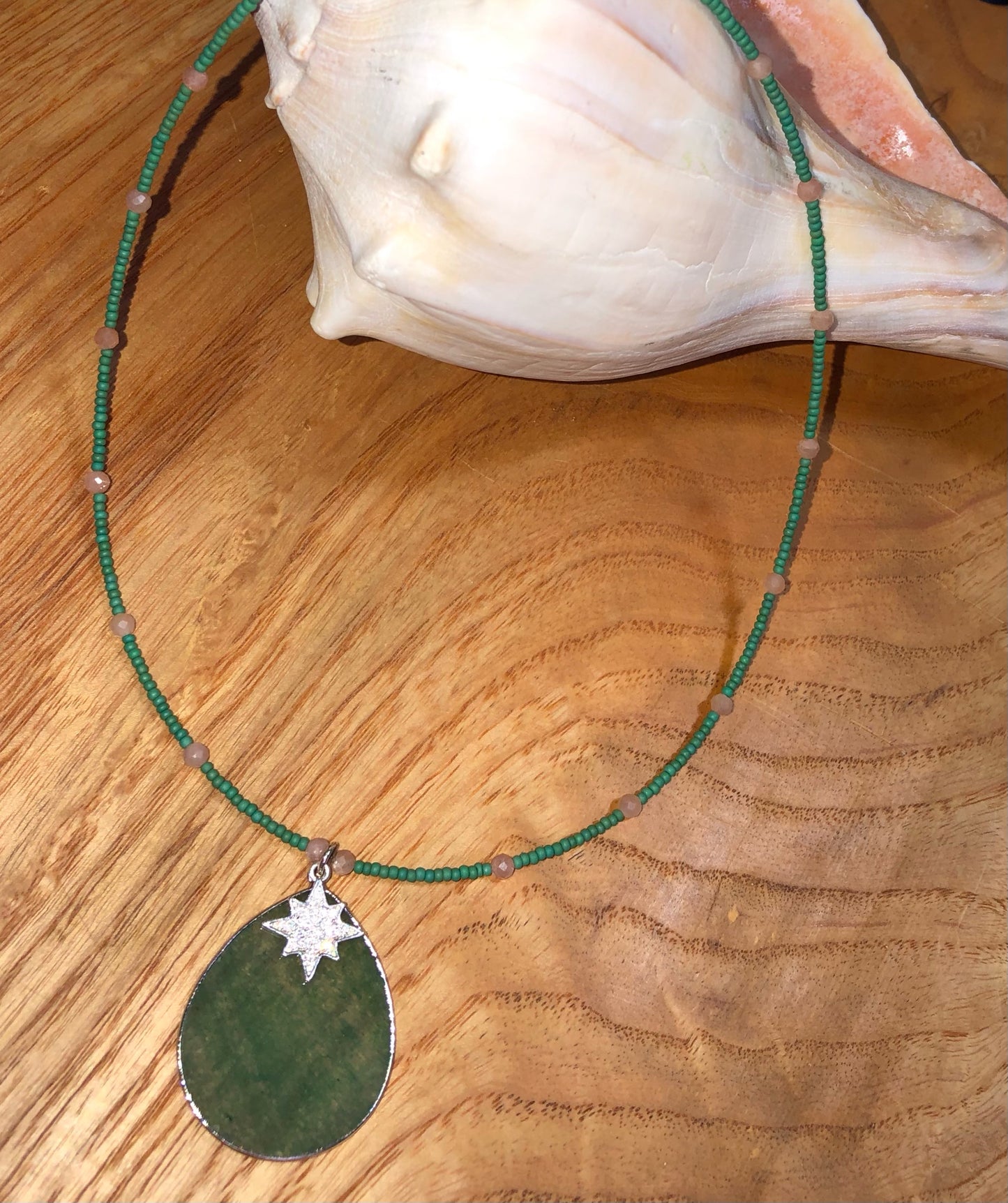 Green aventurine pendant/necklace with peach sunstone beads, green glass seed beads, and 19mm silver plated clear crystal starburst charm.