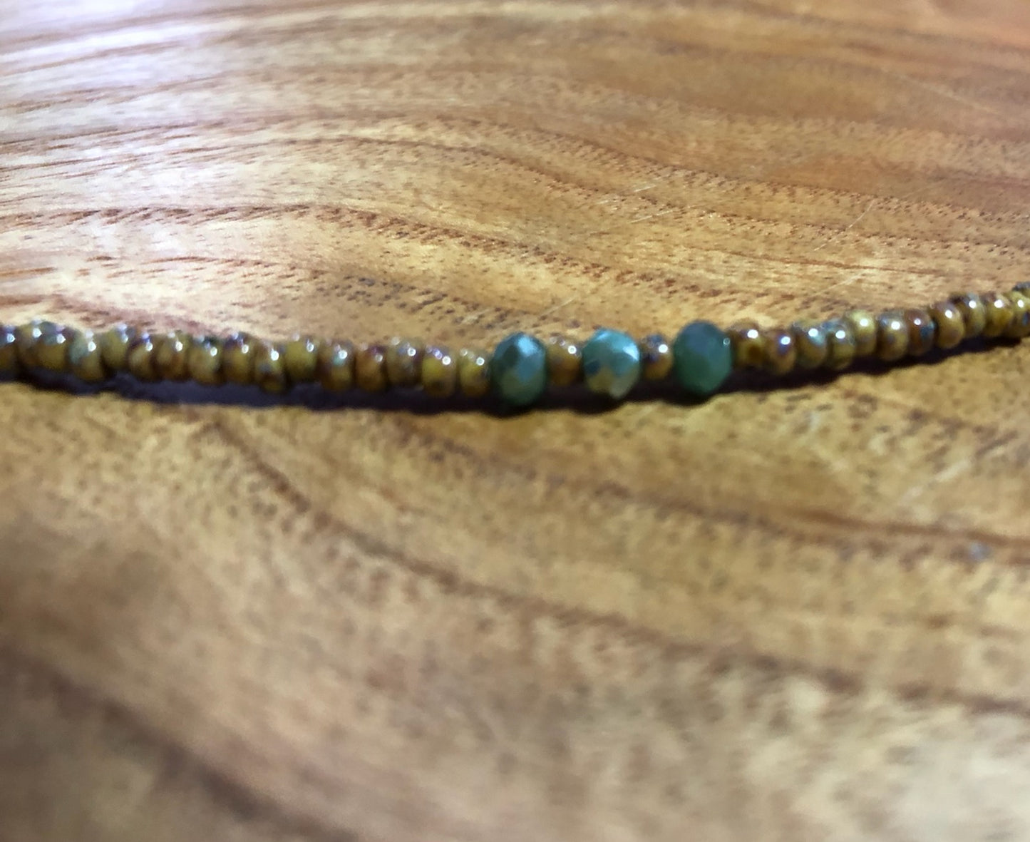 Sandy colored seashell necklace with sand colored glass seed beads and blue glass beads.