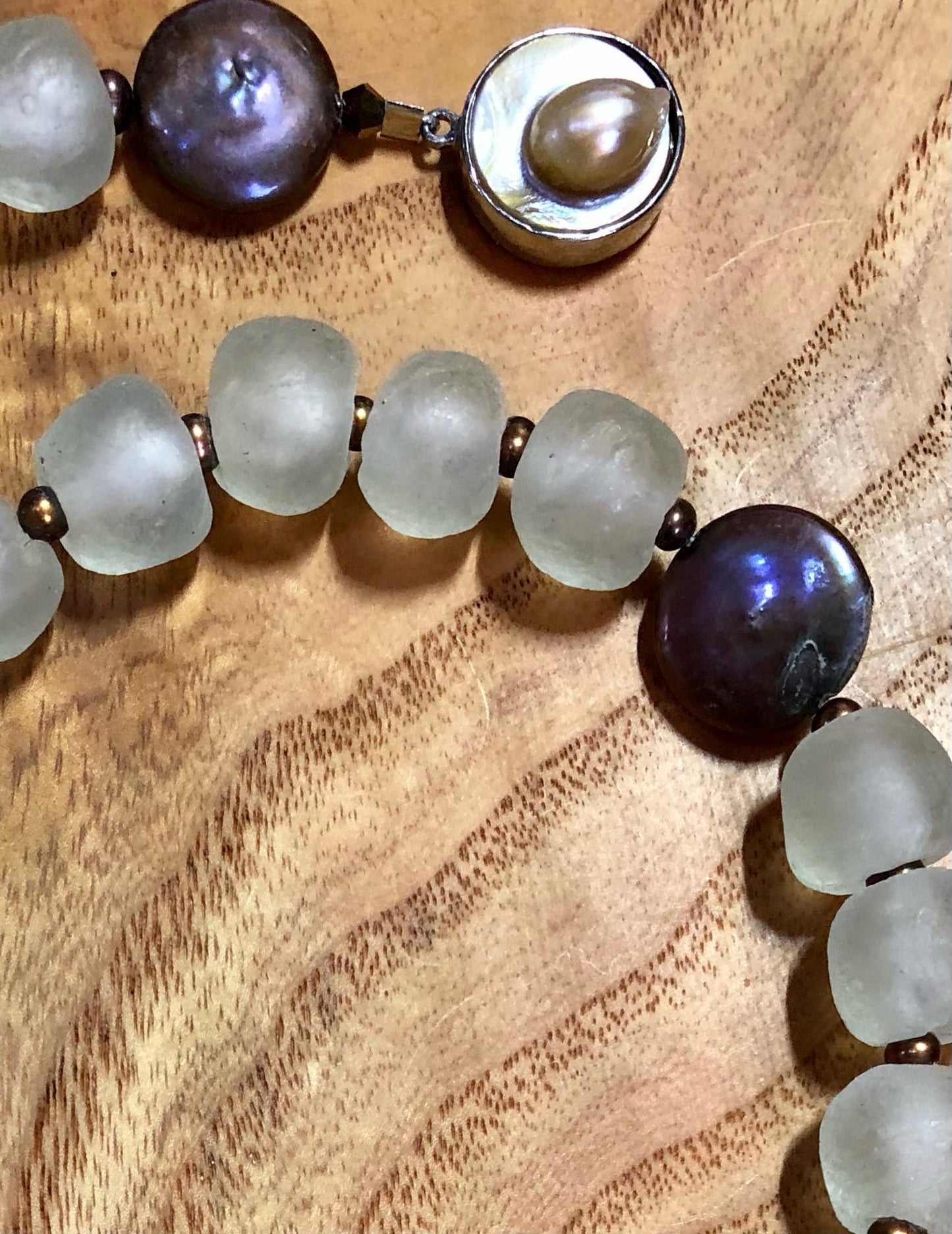 Faceted multi-color agate pendant set in sterling silver with copper coin freshwater pearls, copper freshwater pearls, clear recycled glass beads, and a silver plated pearl clasp.