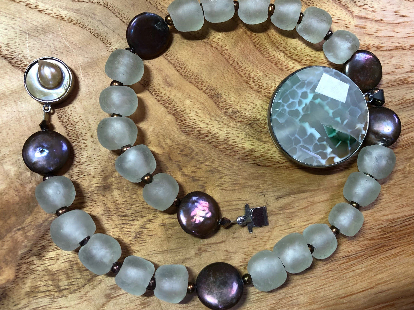 Faceted multi-color agate pendant set in sterling silver with copper coin freshwater pearls, copper freshwater pearls, clear recycled glass beads, and a silver plated pearl clasp.