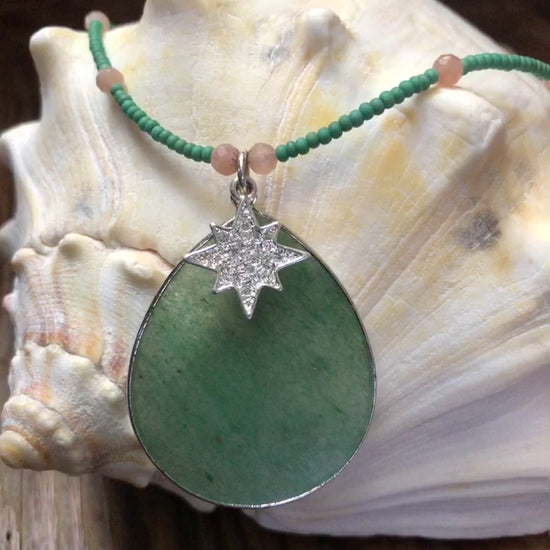 Green aventurine pendant/necklace with peach sunstone beads, green glass seed beads, and 19mm silver plated clear crystal starburst charm.