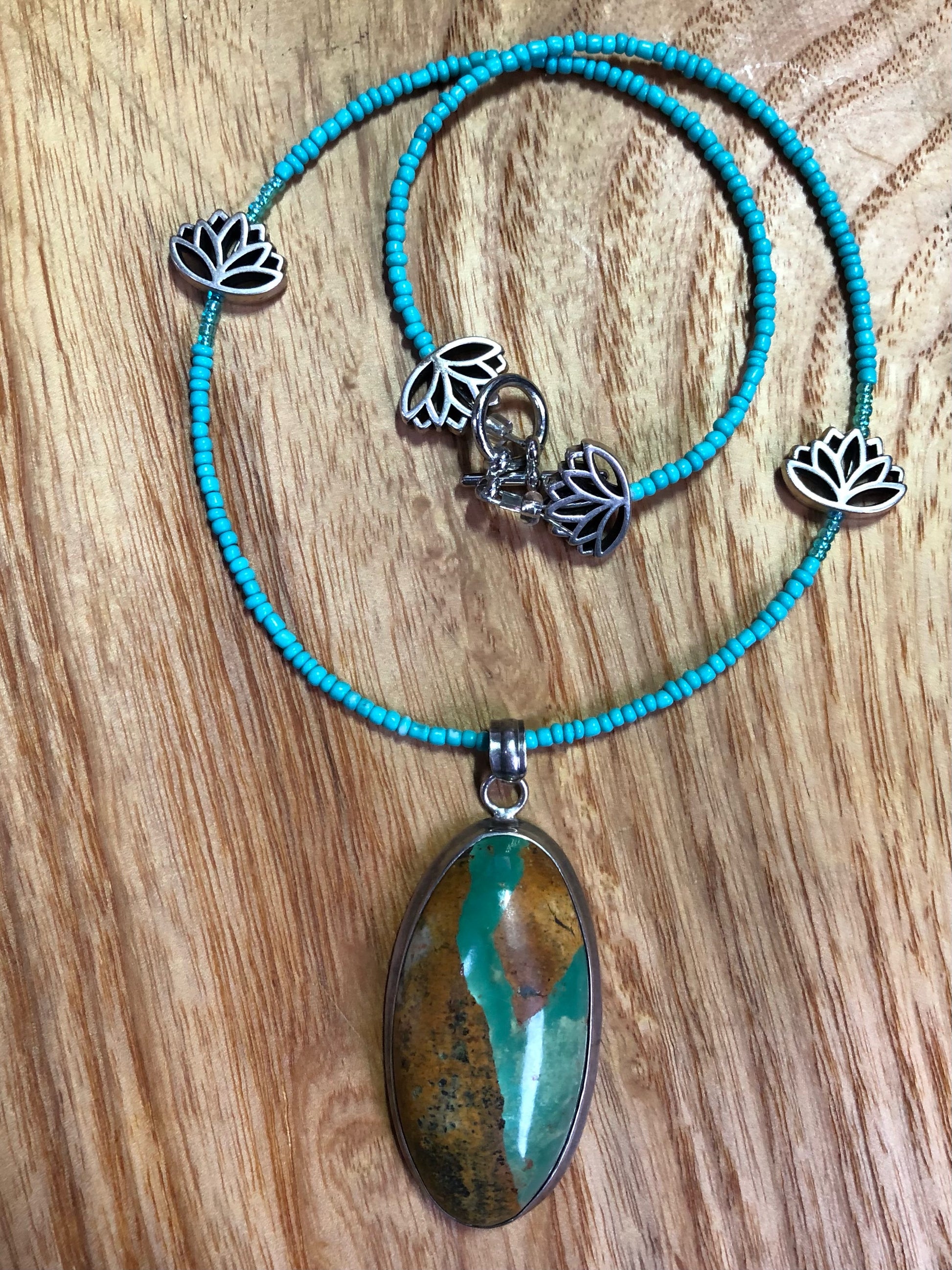 Sterling silver Royston turquoise pendant, strung on a necklace with turquoise glass seed beads, and silver plated lotus beads.
