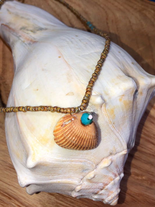 Sandy colored seashell necklace with sand colored glass seed beads and blue glass beads.