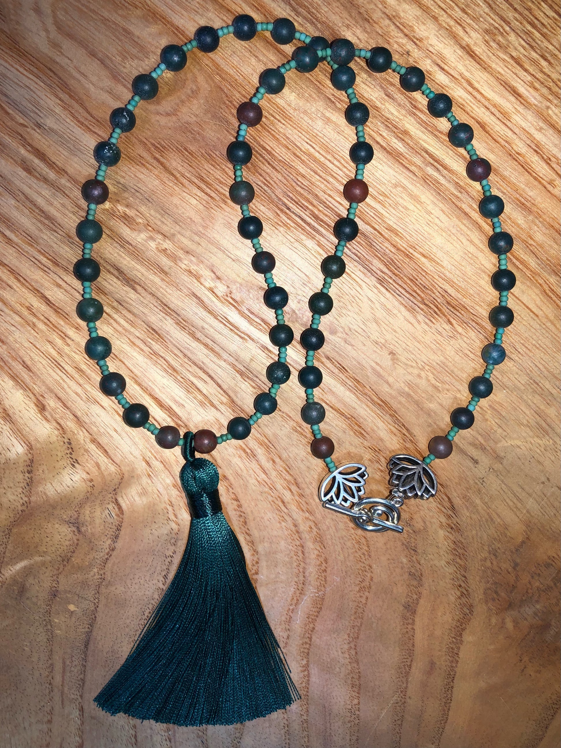54 bloodstone beaded mala with green glass seed beads, silver plated lotus beads, and 3.54" green tassel.