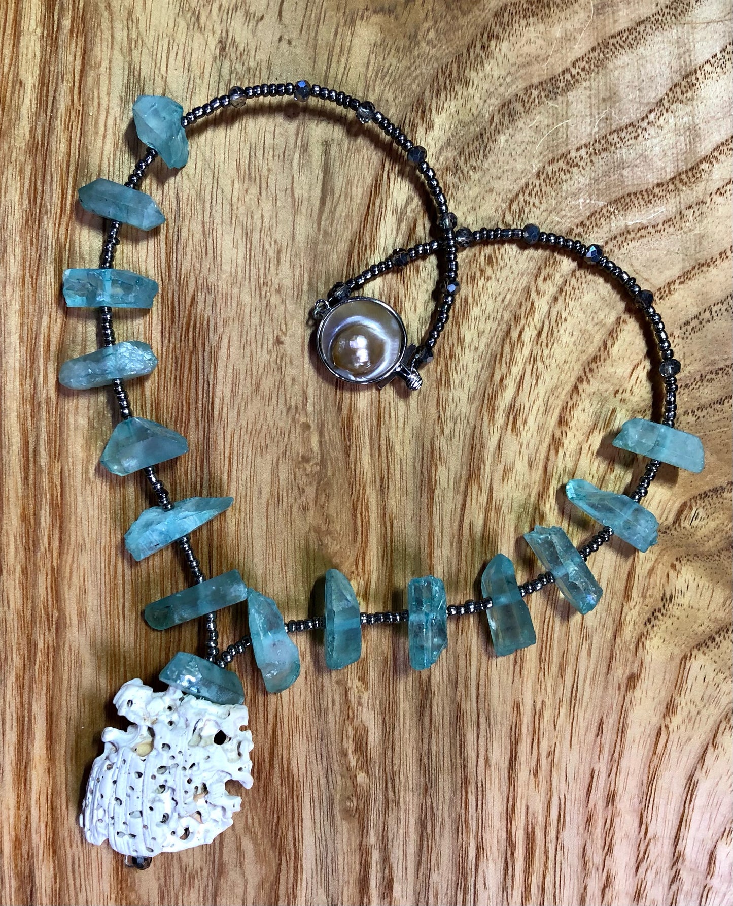 Aqua aura quartz points necklace with white coral, glass seed beads, & silver plated pearl clasp.